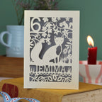 A laser cut birthday card with woodland scene and fox cut out design, personalised with an age in the top left, and a name at the bottom. 