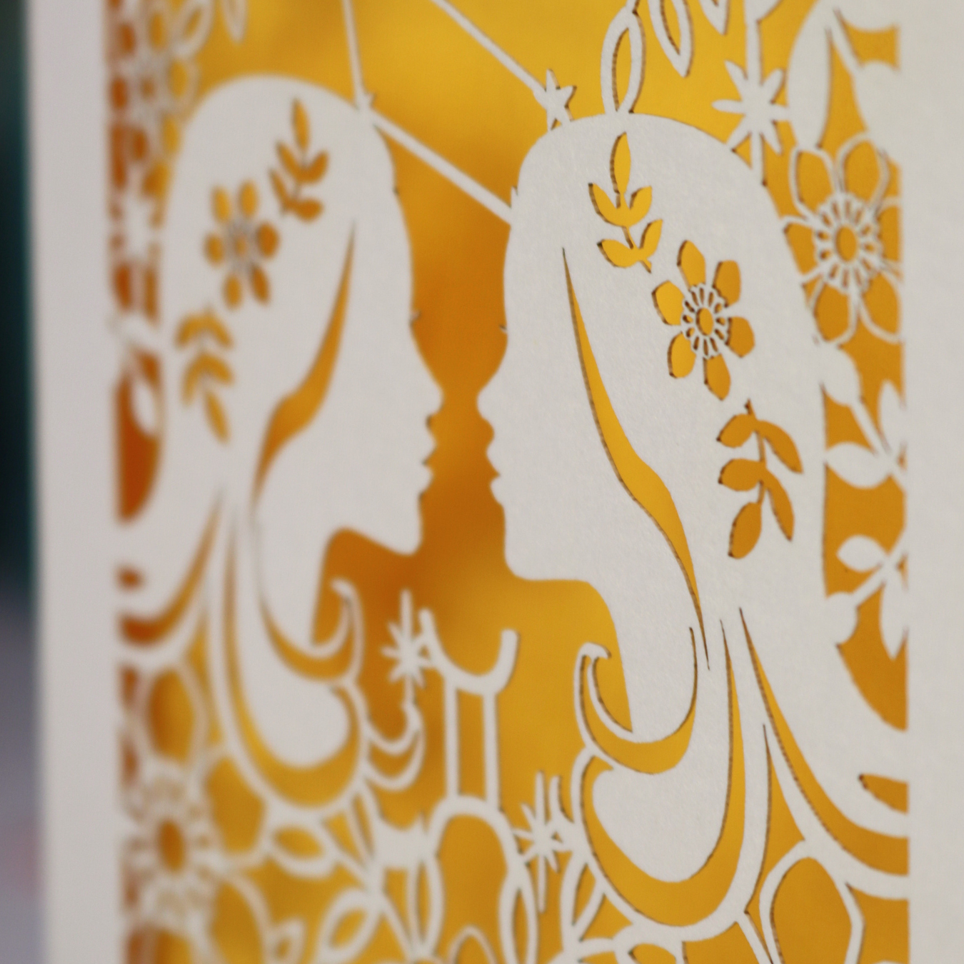 Decorative Gemini Birthday card with laser-cut design and 'Shannon Gemini' text on a desk with stationery items.