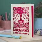 Decorative Gemini Birthday card with laser-cut design and 'Shannon Gemini' text on a desk with stationery items.