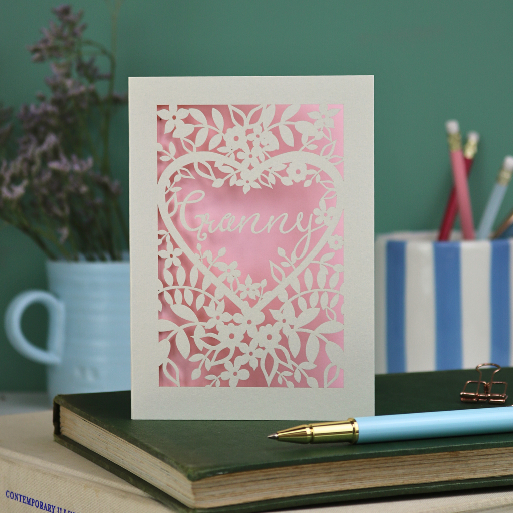 Laser cut greeting Card with floral design and 'Granny' text on a desk with stationery items.