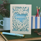 Laser cut greetings Card with floral design and 'Granny' text on a desk with stationery items.