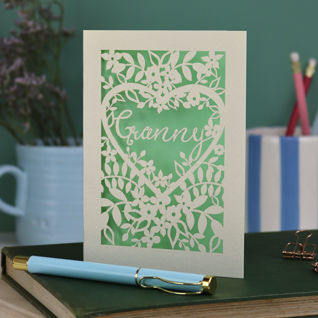 Laser cut Card with floral design and 'Granny' text on a desk with stationery items.