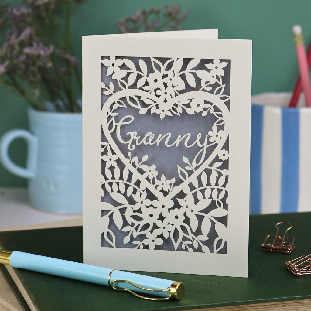 Laser cut Card with floral design and 'Granny' text on a desk with stationery items.
