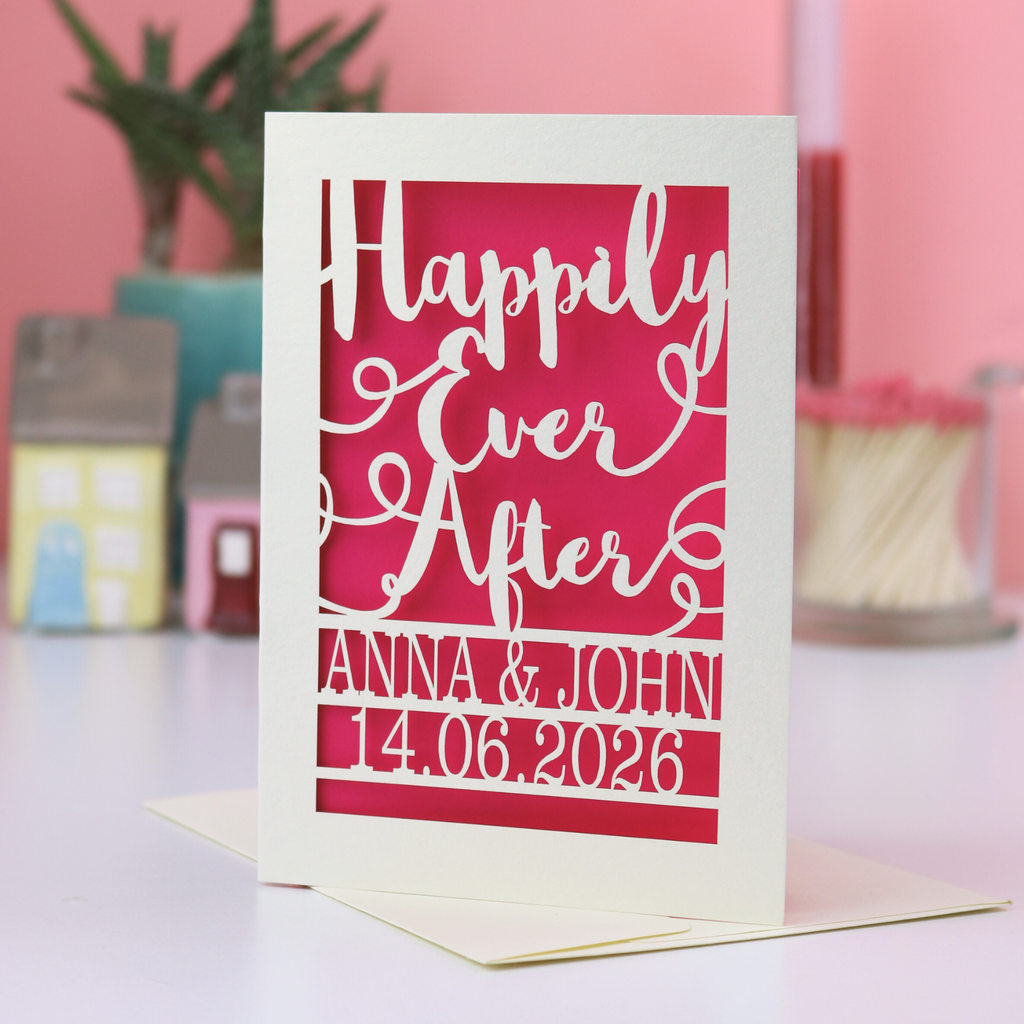 Personalized wedding card with 'Happily Ever After' text and names on a pink background.