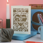 Laser cut Valentine's Card with 'MIKE You make me happy' text on a stand with candles and pens in the background