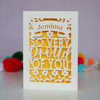 A laser cut congrats card that is personalised with a name and reads "So very proud of you"