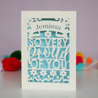 A laser cut personalisable card that is personalised with a name and reads "So very proud of you"