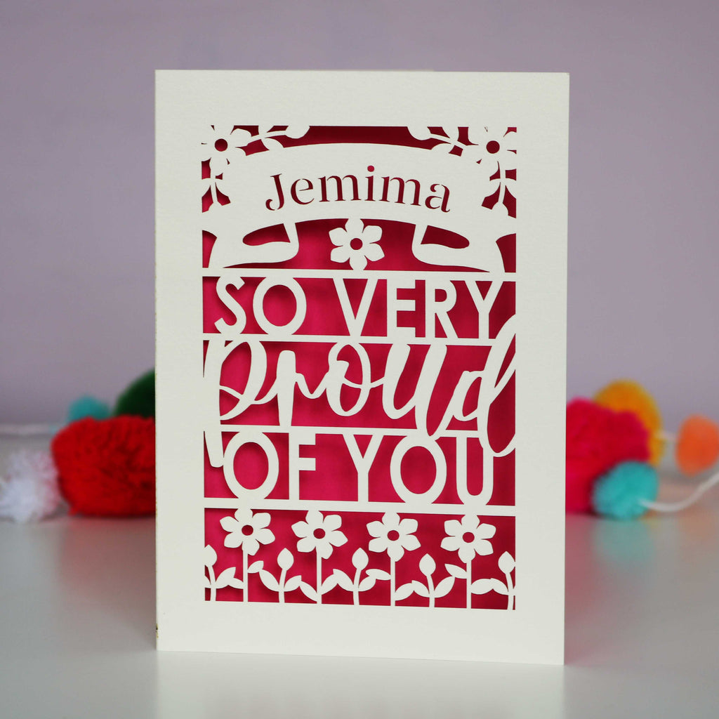 A laser cut congratulations graduation card made in the UK, personalised with a name and reads "So very proud of you"