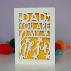 A cream and yellow papercut father's day card that says "Dad, You are my hero"