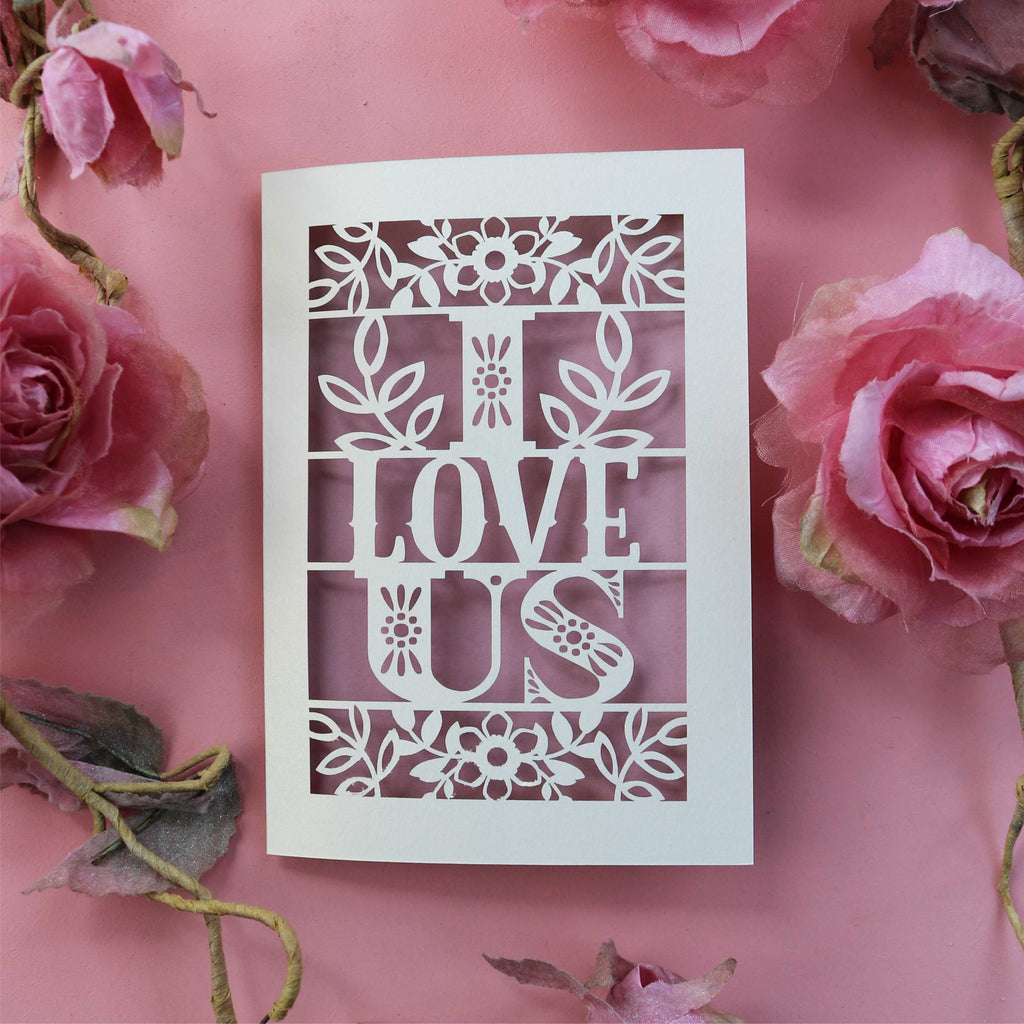 A cut out love Valentine's card with the words 'I LOVE US' cut out.