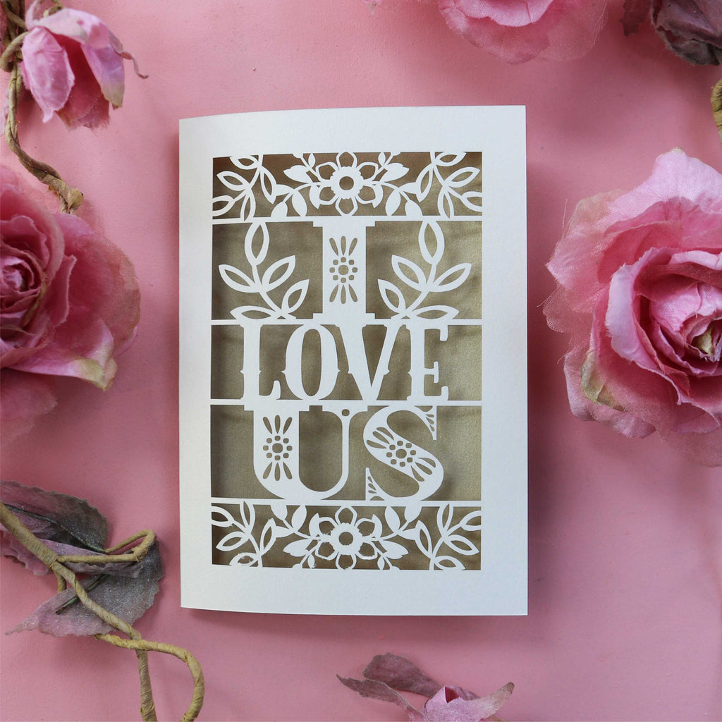A laser cut love Valentines card with the words 'I LOVE US' cut out.