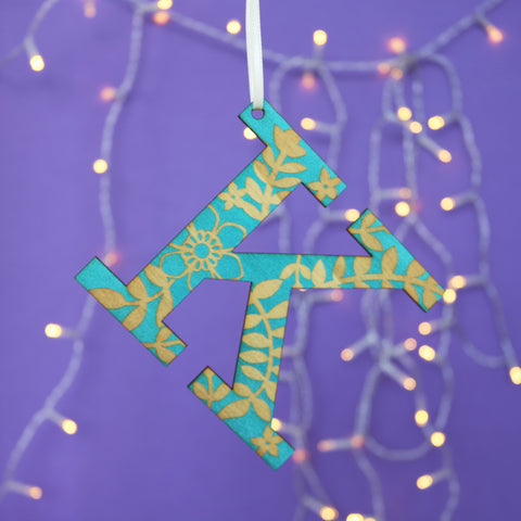 A laser cut initial Christmas decoration in teal.
