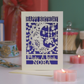 Birthday card with decorative moon and stars design on a table with candles and a gift.