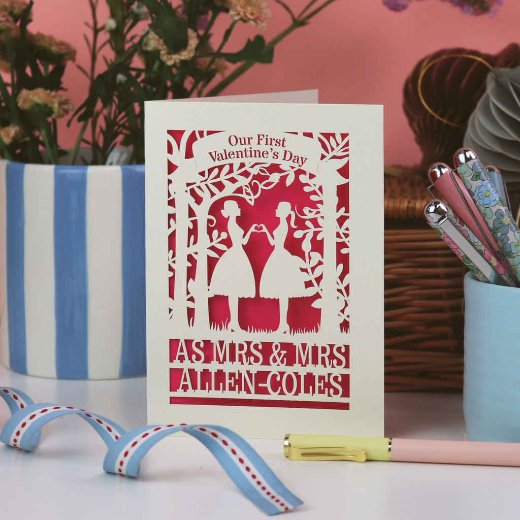 Valentine's Day card with personalized text on a decorative surface with flowers and stationery.