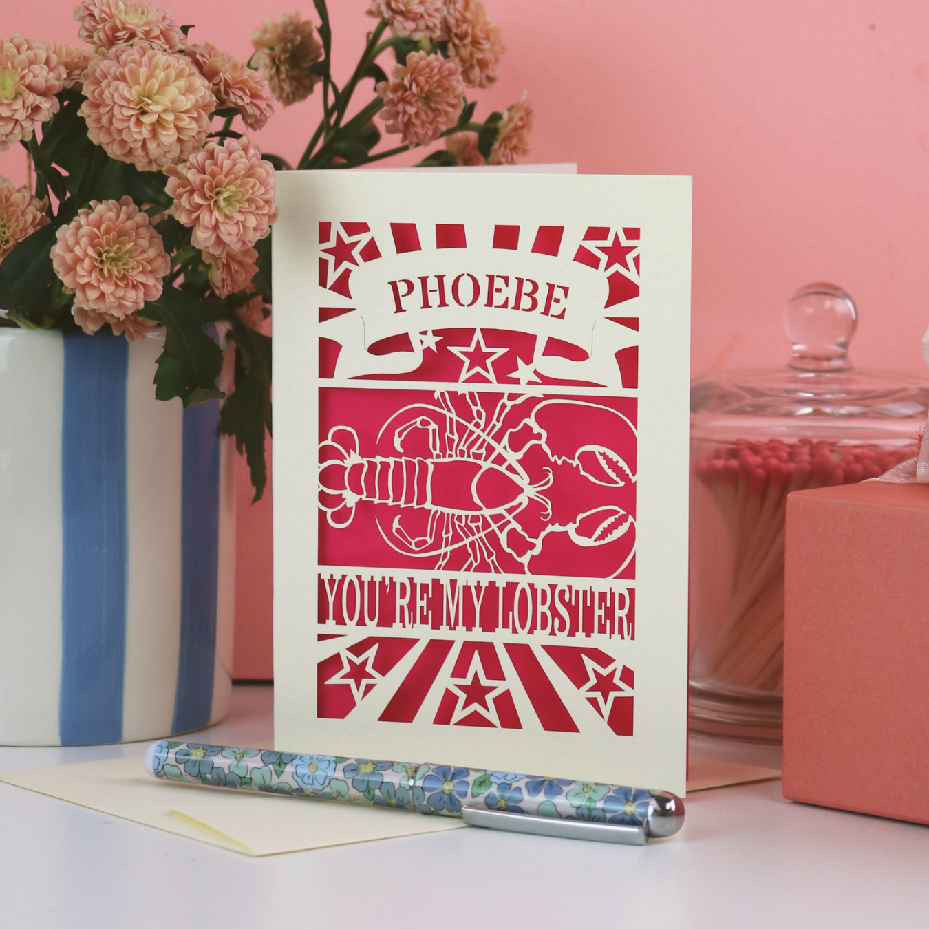 A laser cut Valentine's card that says "Phoebe, you're my lobster" with cut out lobster design. 
