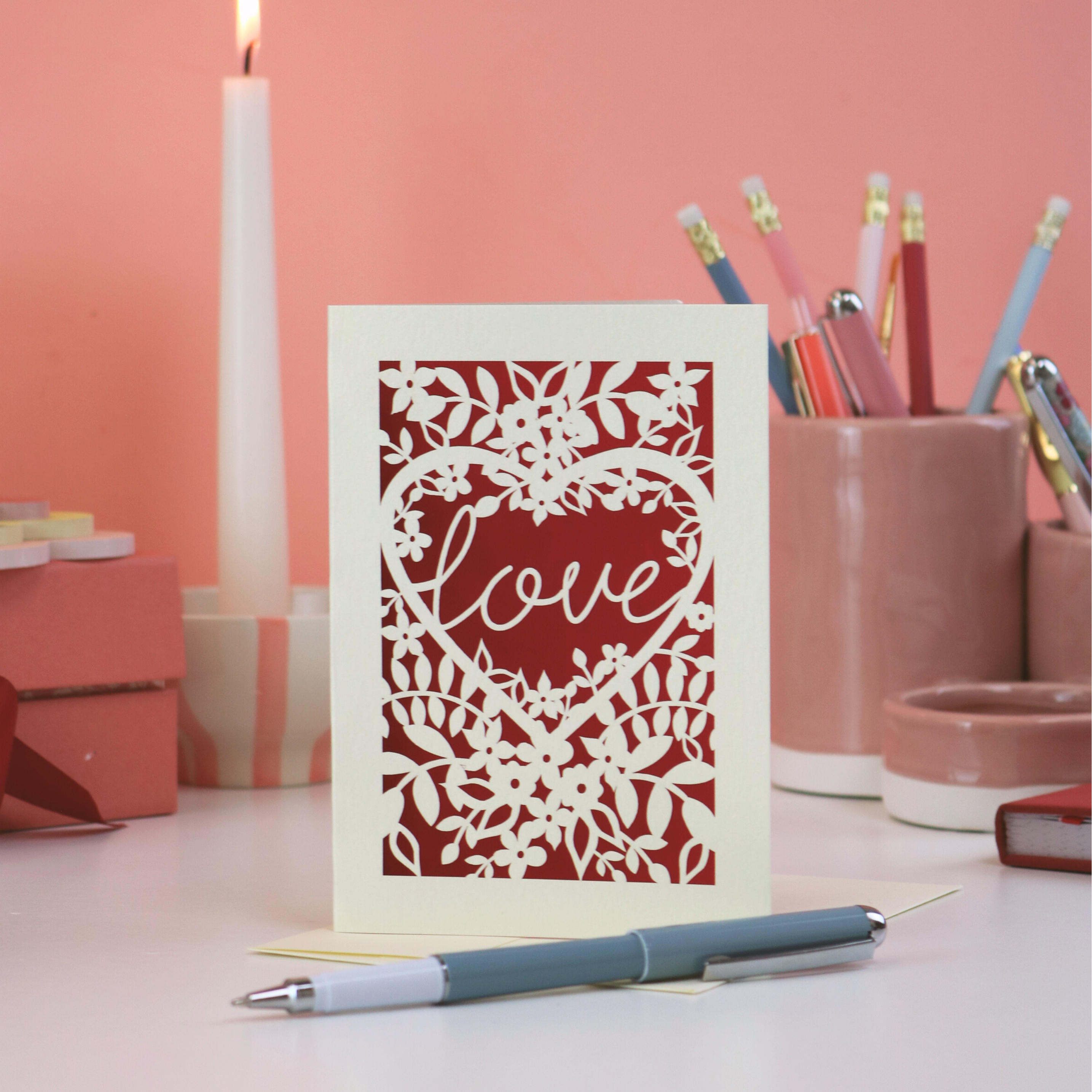 Valentine's Day Card with floral design and 'love' text on a desk with stationery items.