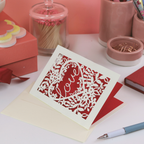 Decorative Valentine's card with floral design and 'Love' text on a desk with stationery items.