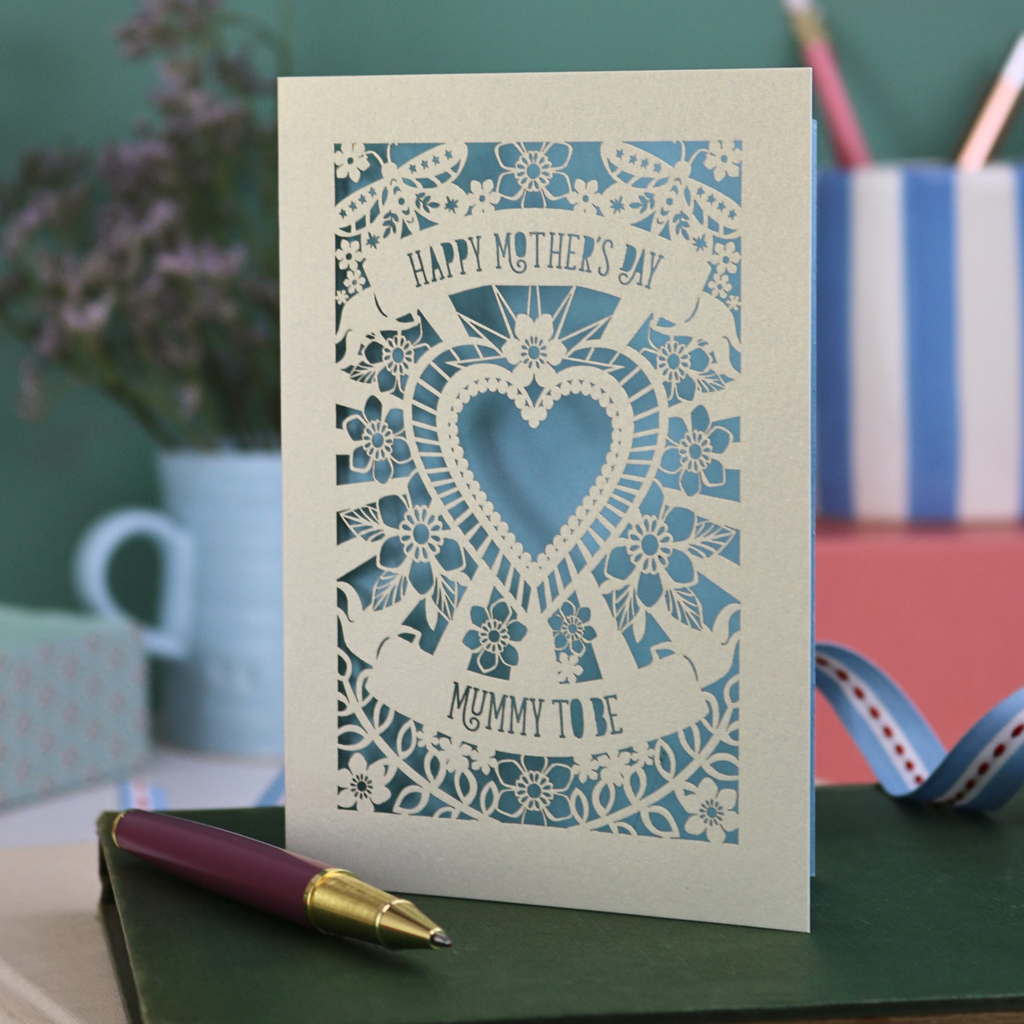 A laser cut Mother's Day card for a Mummy to be, with intricate heart and flower design and text "Happy Mother's Day, Mummy to be"