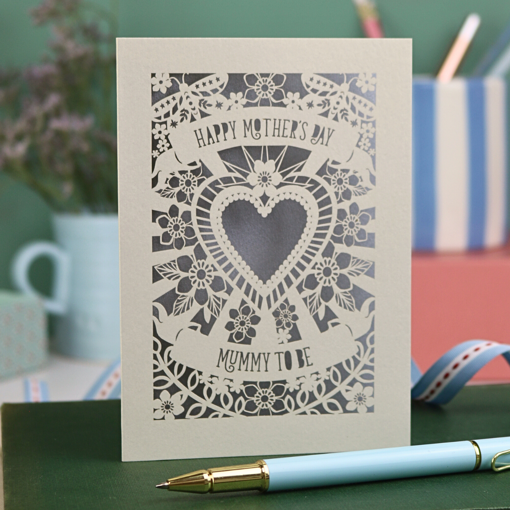 A laser cut Mother's Day card for a Mummy to be, with intricate heart and flower design and text "Happy Mother's Day, Mummy to be"