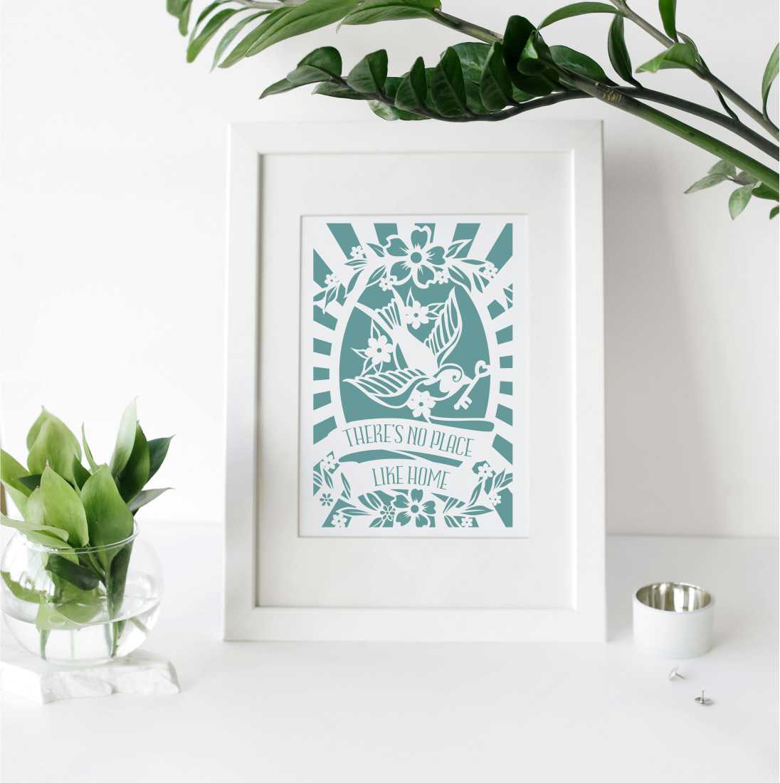 An image of a framed housewarming print that says "There's no place like home"