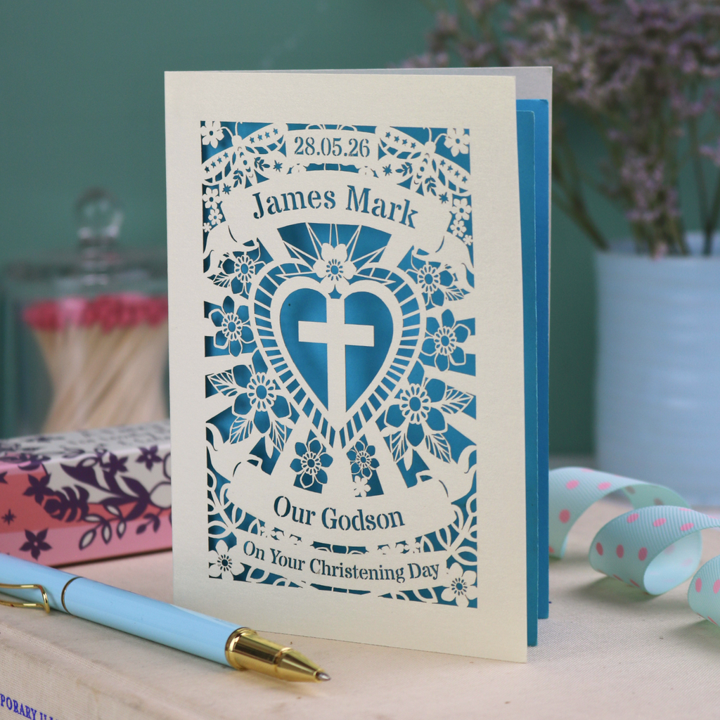 Personalised To Our Godson Christening card with decorative elements on a wooden surface.