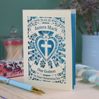 Personalised To Our Godson Christening card with decorative elements on a wooden surface.