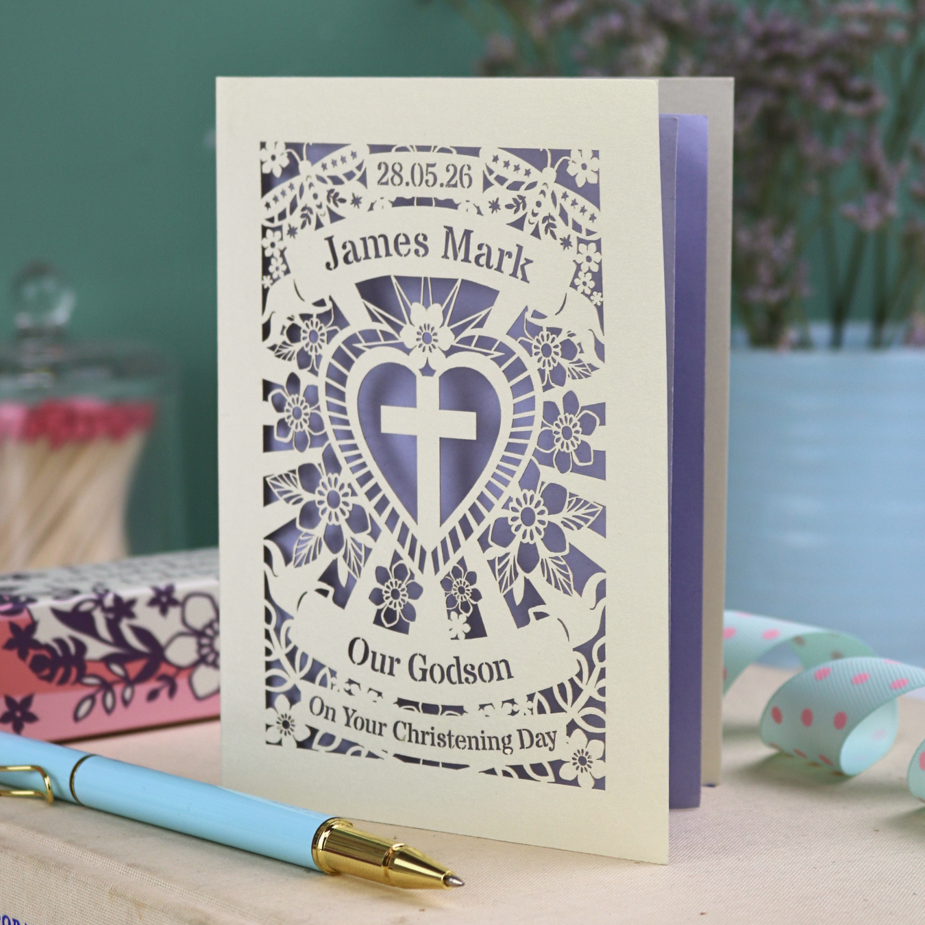 Personalised laser cut Godson Christening card with decorative elements on a wooden surface.