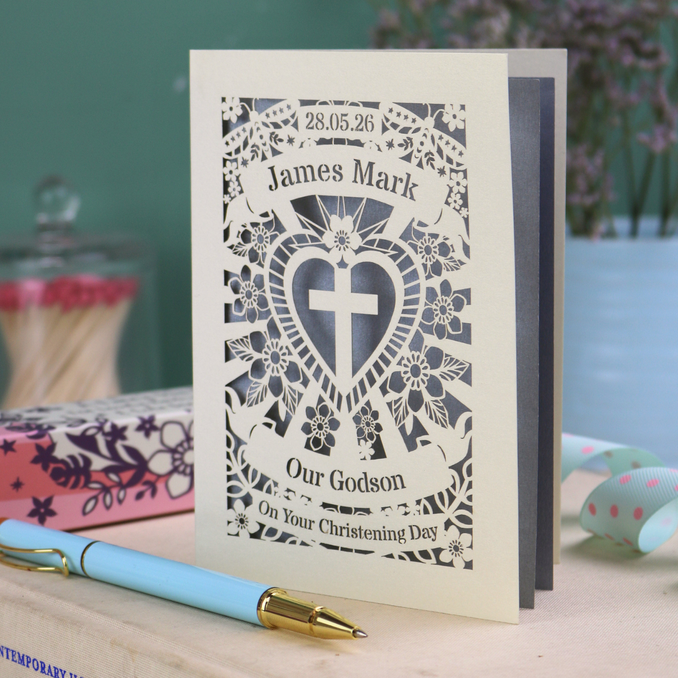 Personalised Keepsake Godson Christening card with decorative elements on a wooden surface.