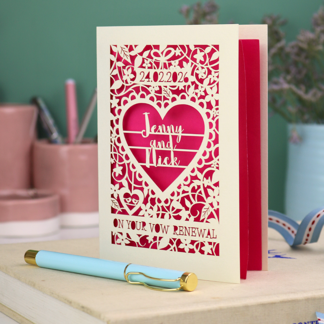 Personalised vow renewal card with laser cut design and text on a desk with stationery items