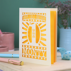 Personalised Baby's 1st Birthday card. laser cut with star borders and "Happy First Birthday" at the top, a decorative cut out number 1 in the centre and personalised with the name "MONTY" at the bottom. card is cream with a bright yellow paper backing