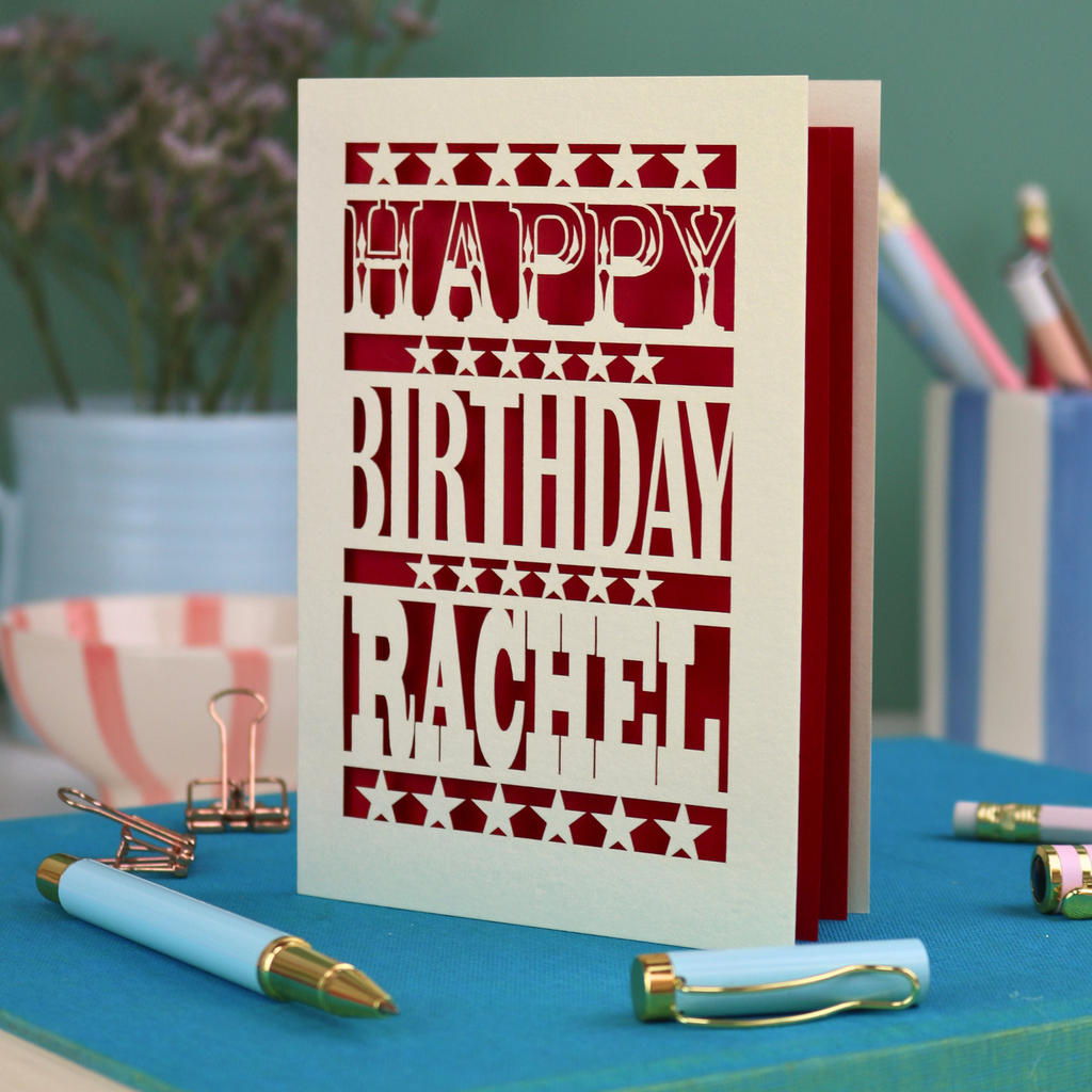A laser cut personalised birthday card that says "Happy Birthday Rachel" in bold text with star design.