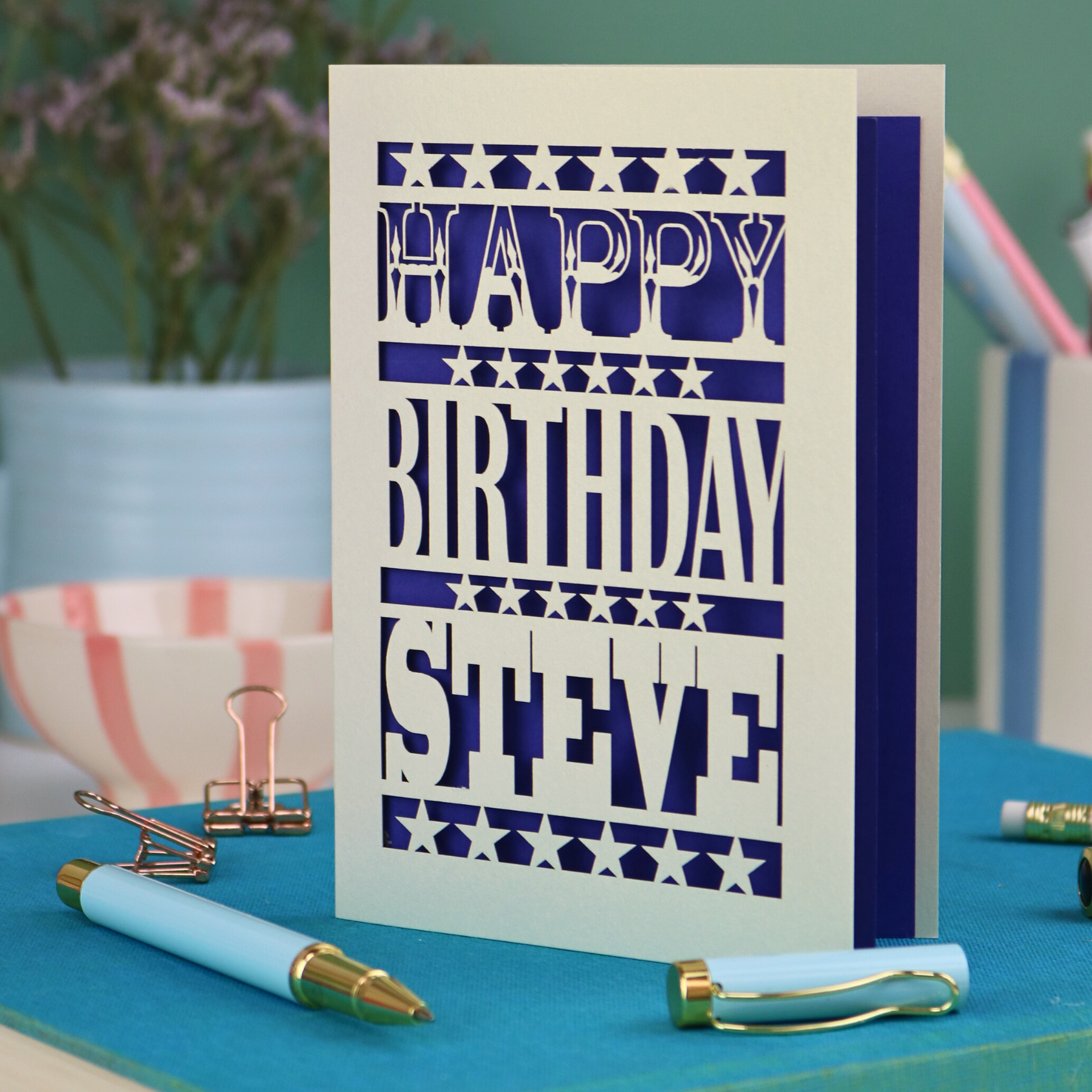 A laser cut personalised birthday card that says "Happy Birthday Steve" in bold text with star design.