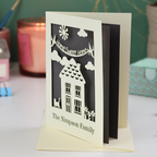 A laser cut new home card with cut out house design and the words "home sweet home" and personalised with the name of the recipients underneath