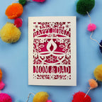 Decorative Diwali card with 'Happy Diwali' and 'Mom & Dad' text on a blue background with colourful pom-poms.