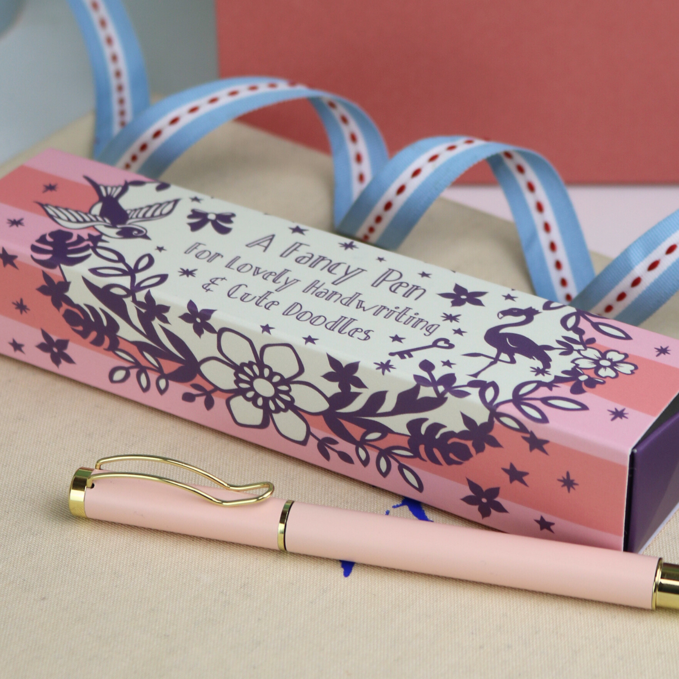 A pastel pink ballpoint pen with a pretty pink and purple gift box