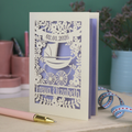 A personalised new baby card with laser cut floral vintage pram design. The baby's date of birth is cut out in stencil lettering in a banner, and the baby's name is at the bottom of the card.