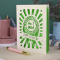 A laser cut cream Father's Day card with cut out rosette design and "No. 1 Dad" in the centre, and a banner with "Happy Father's Day" underneath. 
