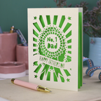 A laser cut cream Father's Day card with cut out rosette design and "No. 1 Dad" in the centre, and a banner with "Happy Father's Day" underneath. 