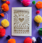 A laser cut personalised Valentines card that has a heart and flowers cut out and text that says "Happy Valentine's Day, love from" and a name