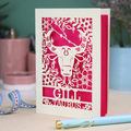 Personalised laser cut Birthday card with zodiac design featuring a bull on a pink background, with a pen and decorative ribbon in the foreground.