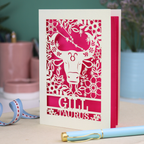 Personalised laser cut Birthday card with zodiac design featuring a bull on a pink background, with a pen and decorative ribbon in the foreground.