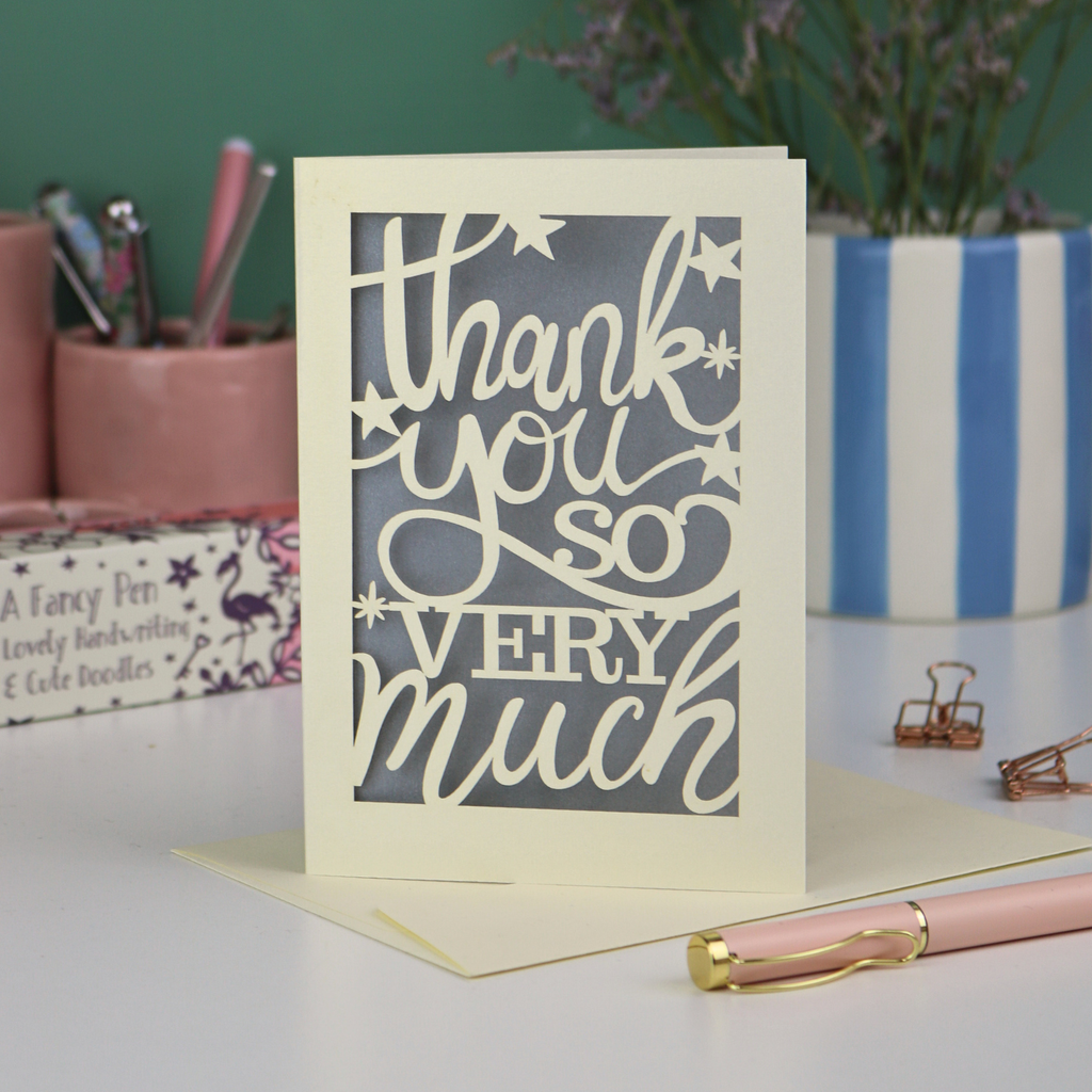 A laser cut Thank You card with handwritten cut out text that says "Thank you so very much", with a silver paper insert. 