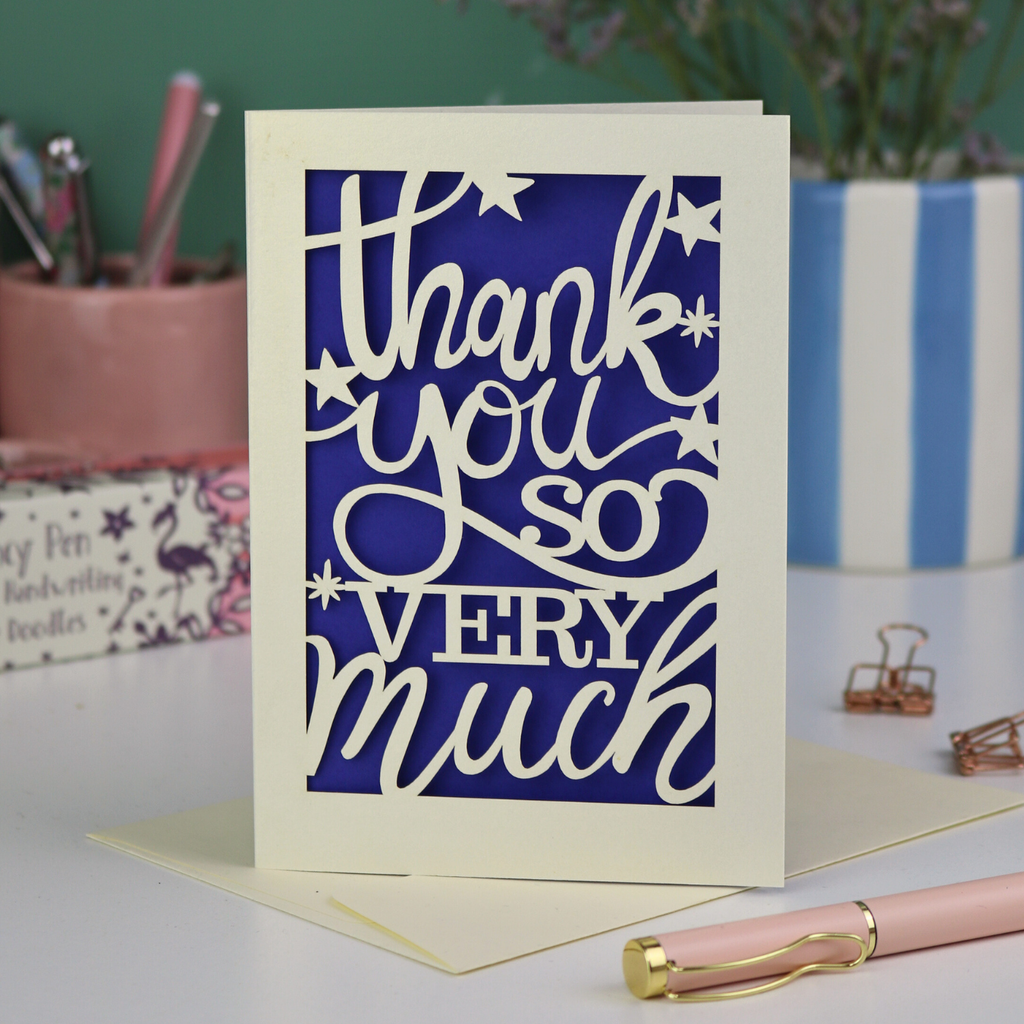 A laser cut Thank You card with handwritten cut out text that says "Thank you so very much", with a violet paper insert. 