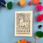 Decorative laser cut Capricorn birthday card with Capricorn zodiac symbol on a blue background with colourful pom-poms.