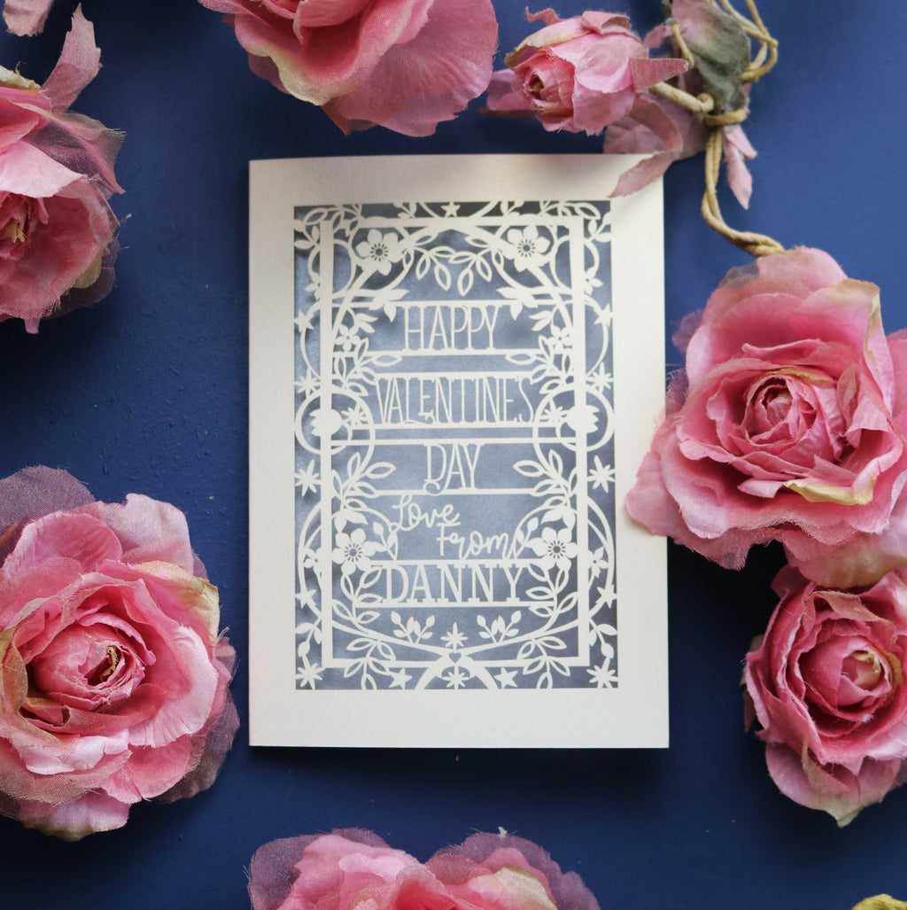 A personalised card for Valentine's Day, laser cut with a floral and star border and the words "Happy Valentine's Day, Love from NAME"