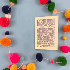 Personalised birthday Card opening and closing in a stop motion, with carousel design and 'FREYA' text on a blue background with colourful pom-poms.