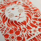 A laser cut greetings card based on the Strength tarot card, with cut out lion design and the word "Strength" 