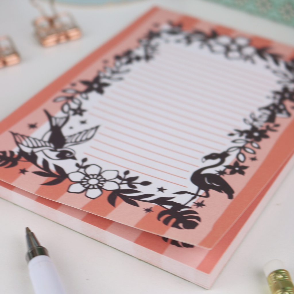 Notepad with decorative flamingo design on a white surface
