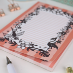 Notepad with decorative flamingo design on a white surface