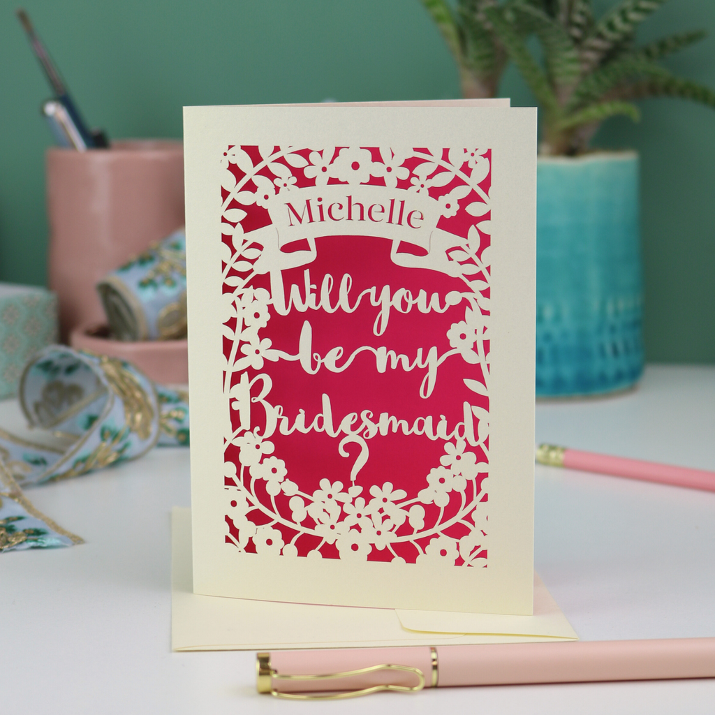 Laser cut Card with 'Will you be my Bridesmaid?' text on a desk with stationery items.